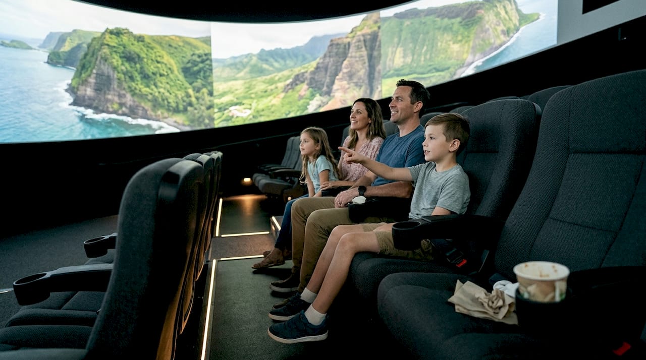 Family watching Hawaii flying theater screen