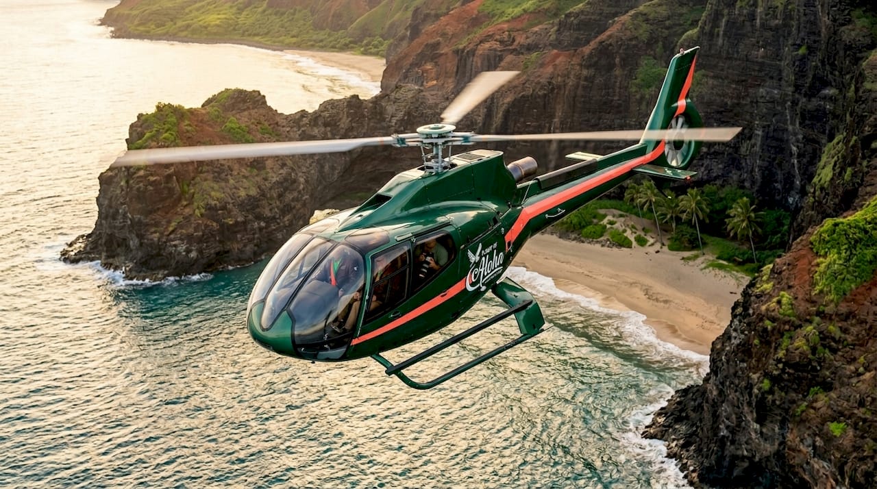 Helicopter flying over Hawaiian coastline aerial view