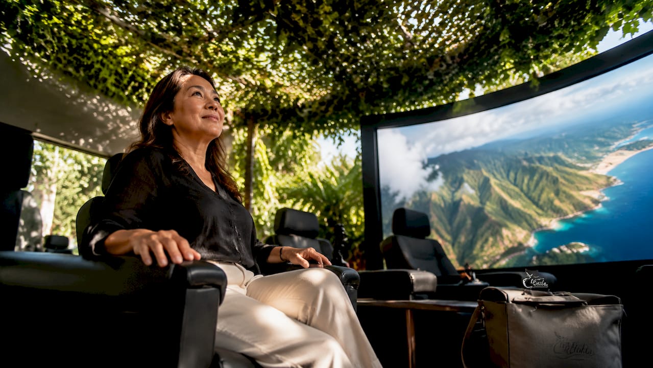 Visitor seated in Hawaiian flight theater experience