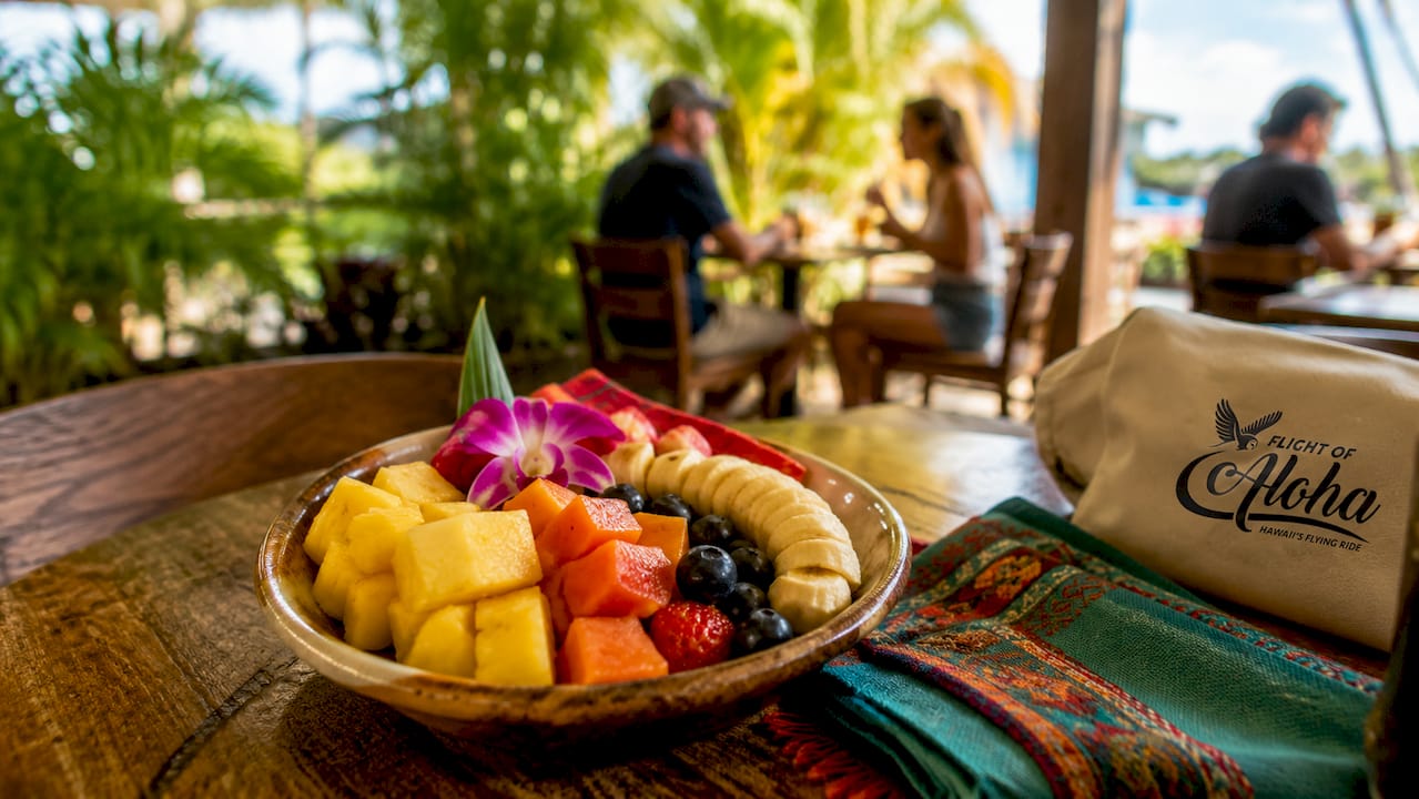 Open-air Kona airport terminal with travelers outdoors