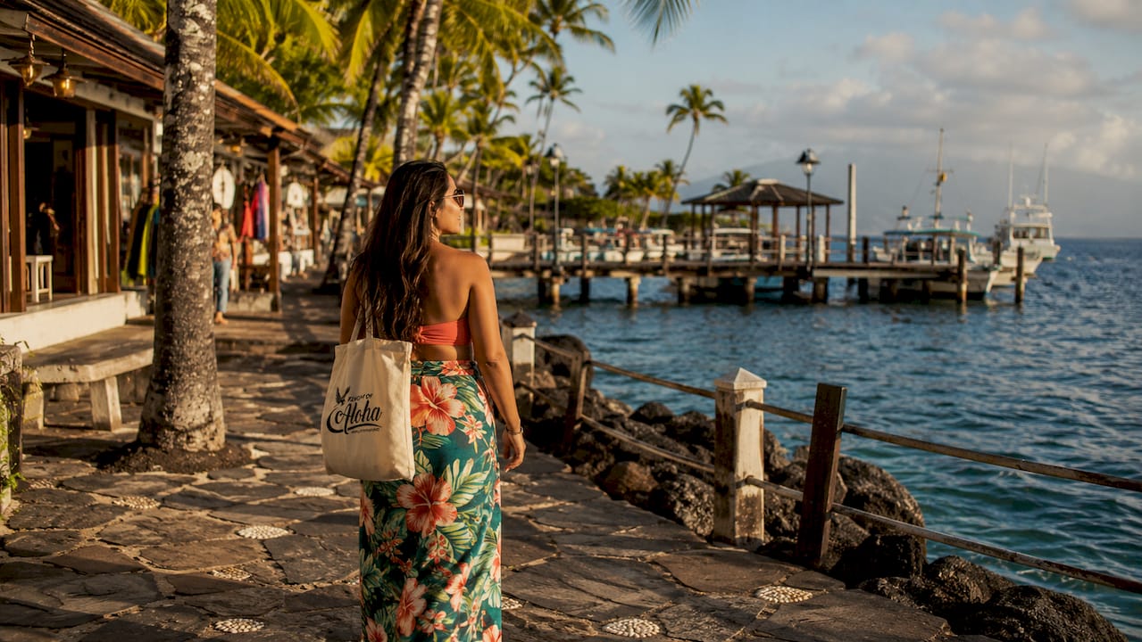Traveler strolling Kona cruise port waterfront at sunrise