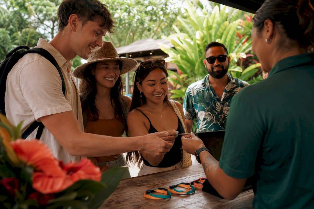 Hands buying group tickets at Hawaiian theater kiosk