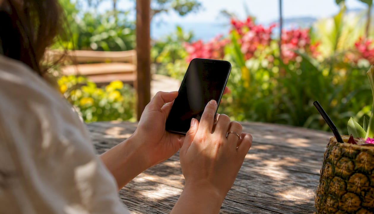 Hands holding smartphone for booking Flight of Aloha tickets