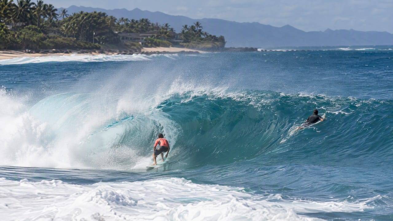 Surfers riding a winter wave at Pipeline