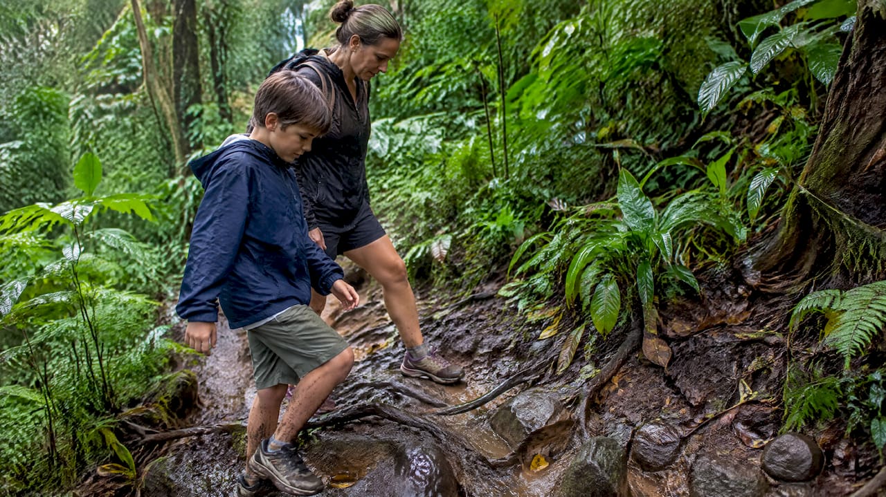Family navigating muddy Oahu trail
