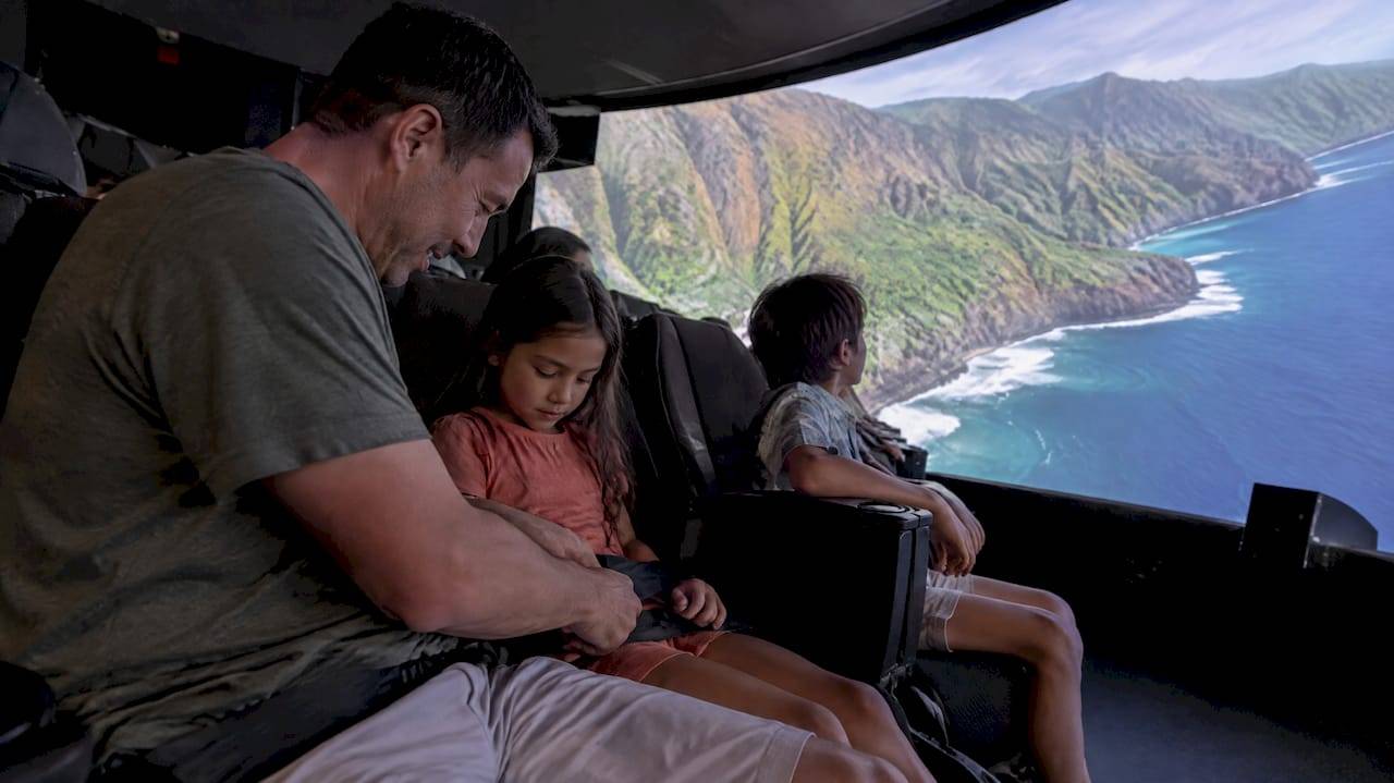 Family settling into Kona flight simulator seats