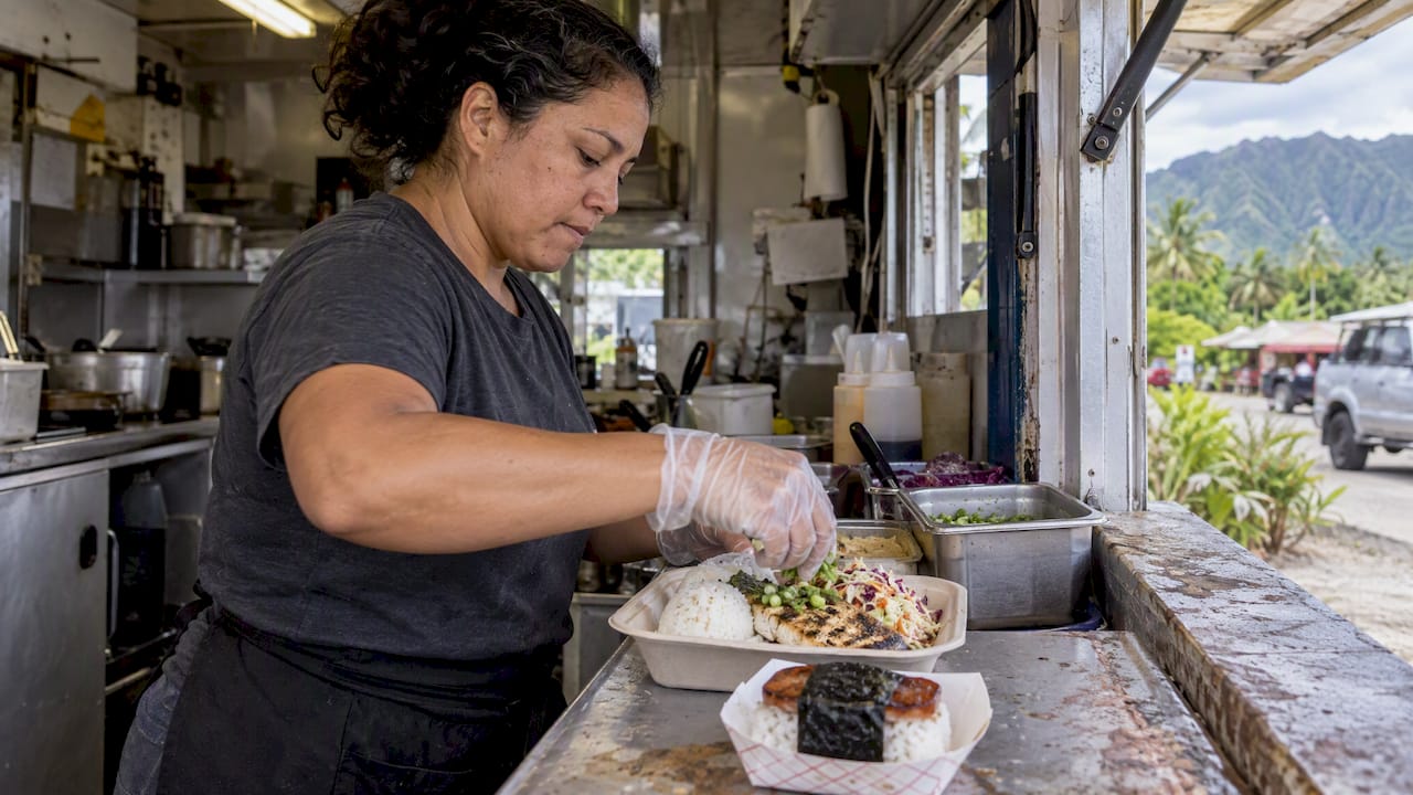Cook preparing plate lunch and musubi